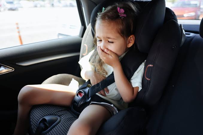 Child feeling car sick in a car seat