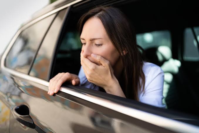 Passenger feeling nauseous leaning out of a car window